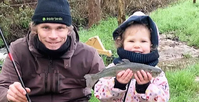 photo  aidée de son papa, benjamin, la petite violette montre fièrement une truite, sa toute première prise.  &copy;  le maine libre 