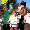 photo  de gauche à droite : coraline, gwenaëlle et gauvin ont reçu leurs diplômes de cowgirl ou cowboy, accompagnés de la shérif en arrière-plan. 