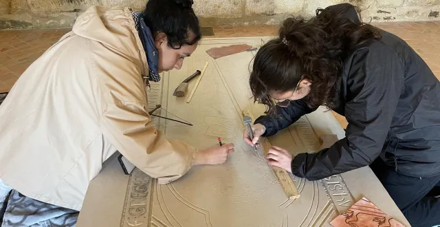 photo  chloé et inès, étudiantes en deuxième année de master patrimoine et développement local à l’université du mans (sarthe), travaillent sur les finitions de la pierre tombale.  &copy;  ouest-france 