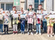 photo  sandrine plessix (à droite) accompagnée de membres de la confrérie des chevaliers des rillettes sarthoises (en arrière-plan) et des enfants d’une des deux classes ayant participé au concours. 