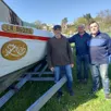 photo  à la base nautique de noron, la yole szrab arrivée sur sa remorque. de gauche à droite : alain auzanneau (chef de bord), christophe et patrick, membres de yole nautisme développement. 