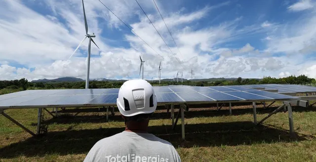 photo  un employé de totalenergies se tient devant des panneaux solaires et des éoliennes du parc éolien de la perrière à sainte-suzanne, sur l’île française de la réunion, le 22 janvier 2025. photo d’illustration.  &copy;  richard bouhet/afp archives 