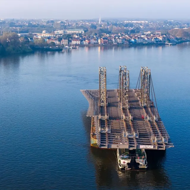 photo ce mardi 24 mars, 8 h 09 : la barge qui transporte le tablier laisse derrière lui le quartier de trentemoult, à rezé, pour arriver dans le bras de la madelaine.  ©  franck dubray / ouest france