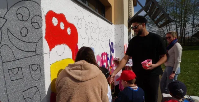 photo  l’artiste wikilynca, lors de la mise en couleurs de la fresque en présence de parents et des membres de l’équipe pédagogique  &copy;  le maine libre. 