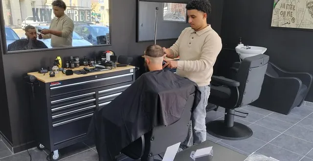 photo  enzo boodhoo, manager du salon krys barber de longué-jumelles, en pleine activité avec son client.  &copy;  co 