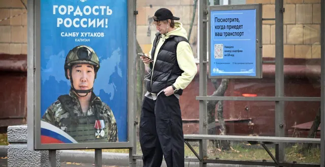 photo  un jeune moscovite devant une affiche incitant les russes à s’enrôler. ici, en octobre 2024.  &copy;  archive alexander nemenov/afp 