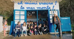 actu cin&eacute;ma  la créatrice de mimi cracra agnès rosenstiehl et les jeunes élèves rassemblés devant la cabane de plage de la potinière à carteret. 